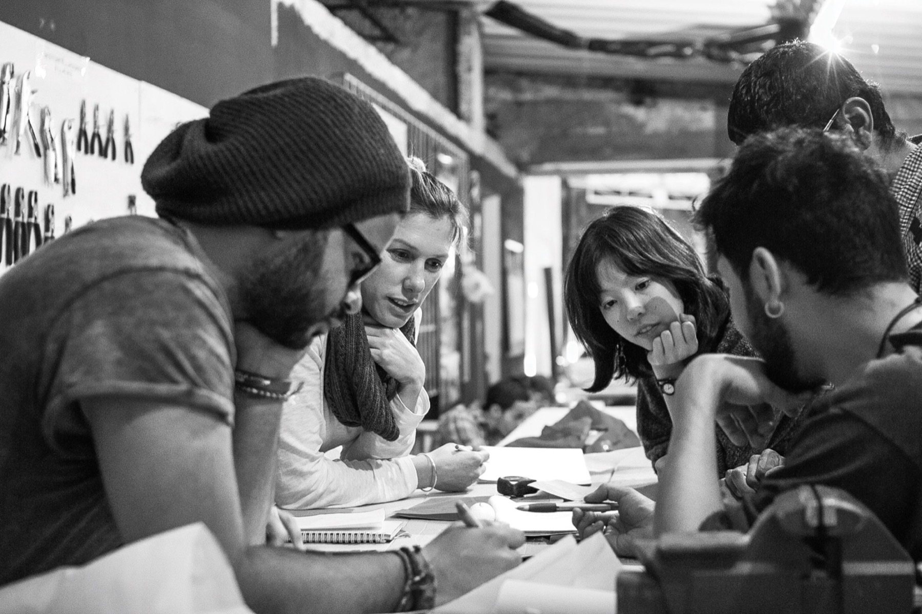 Participants sketching together around a workbench