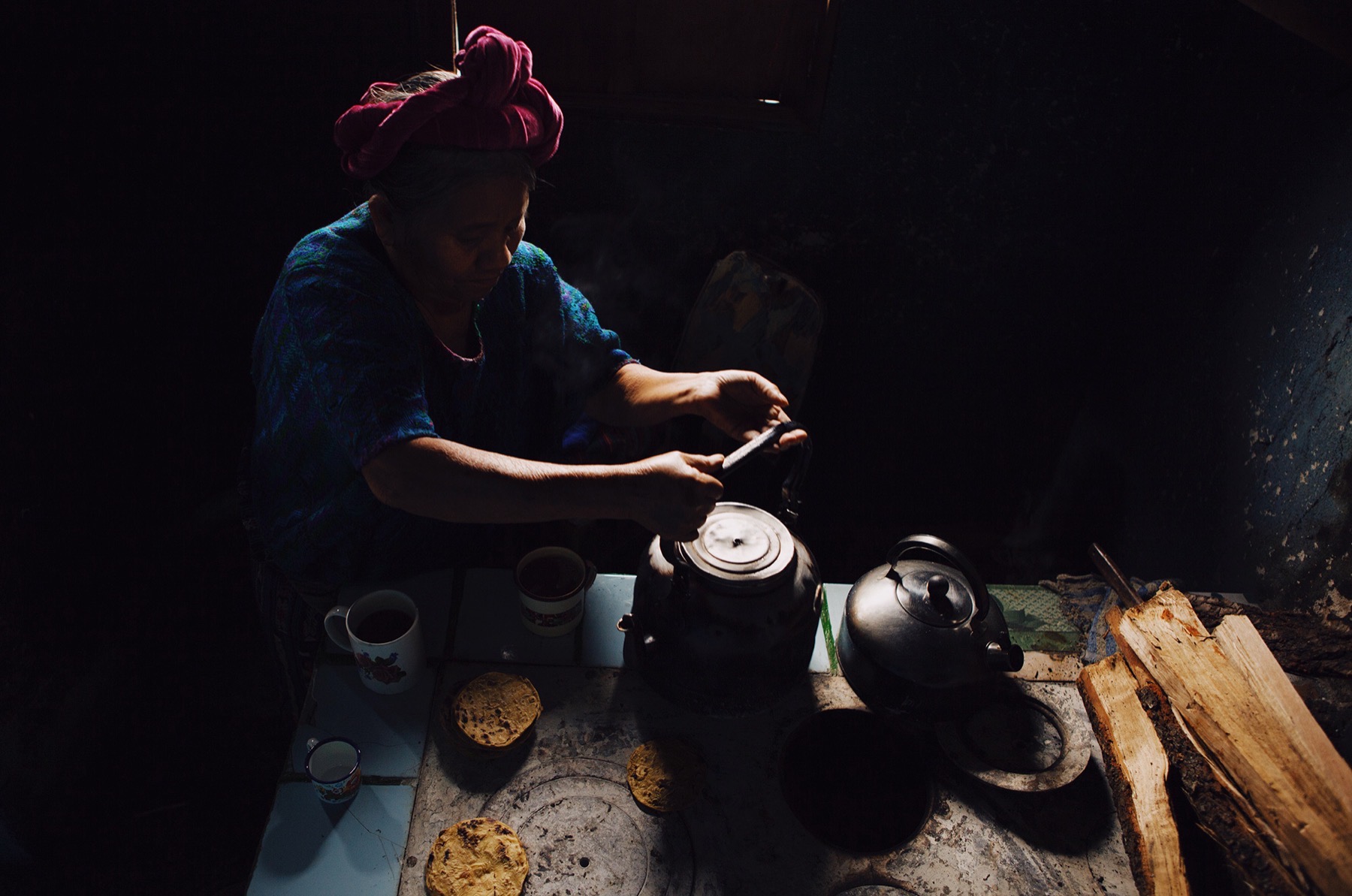 A woman cooking over the fire in her kitchen