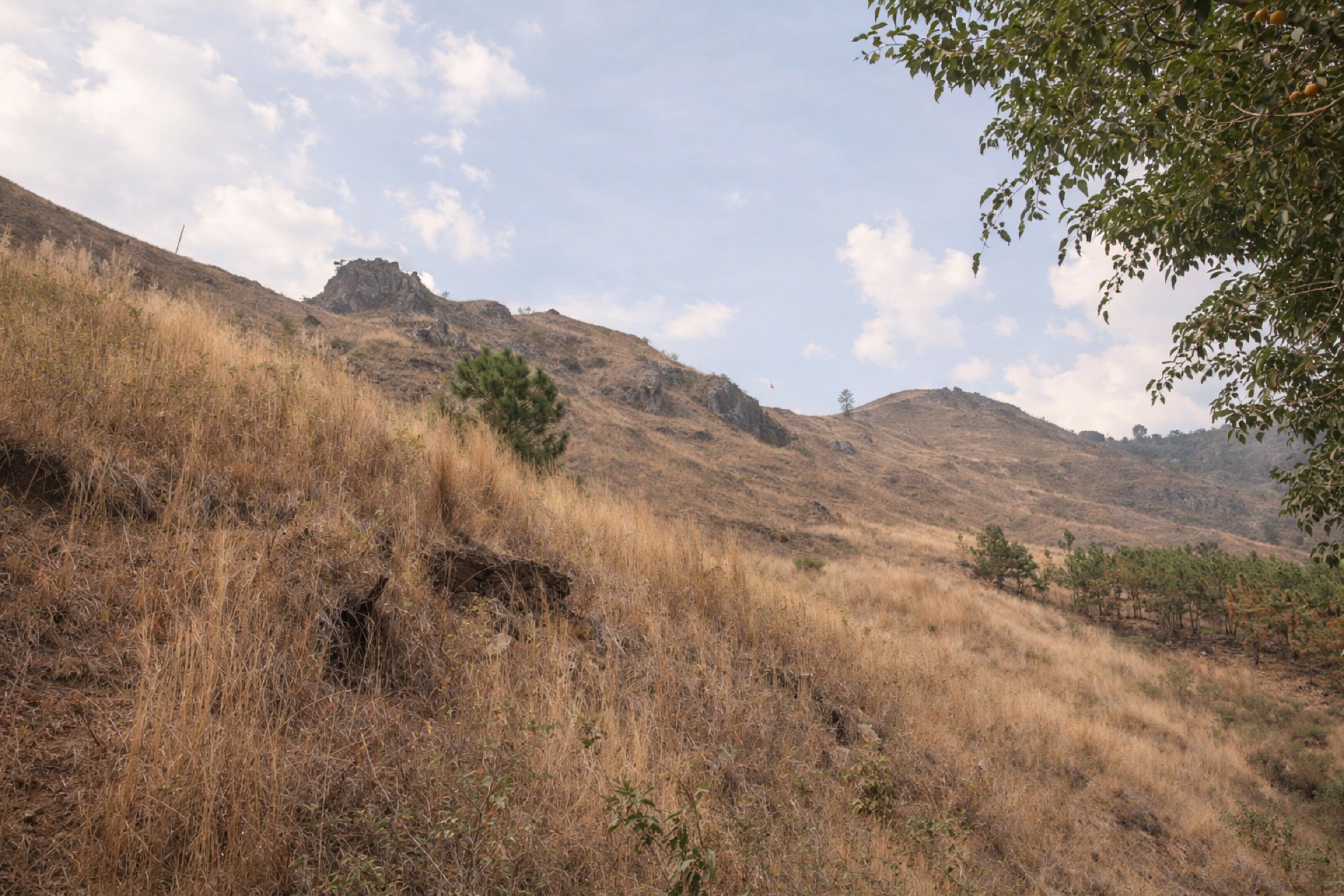 Dry grass hills rising above Lake Atitlán